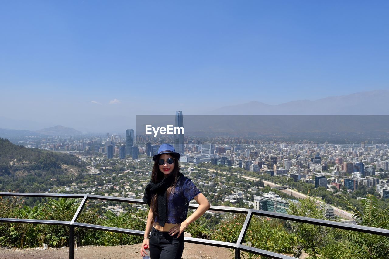 Young woman standing against cityscape