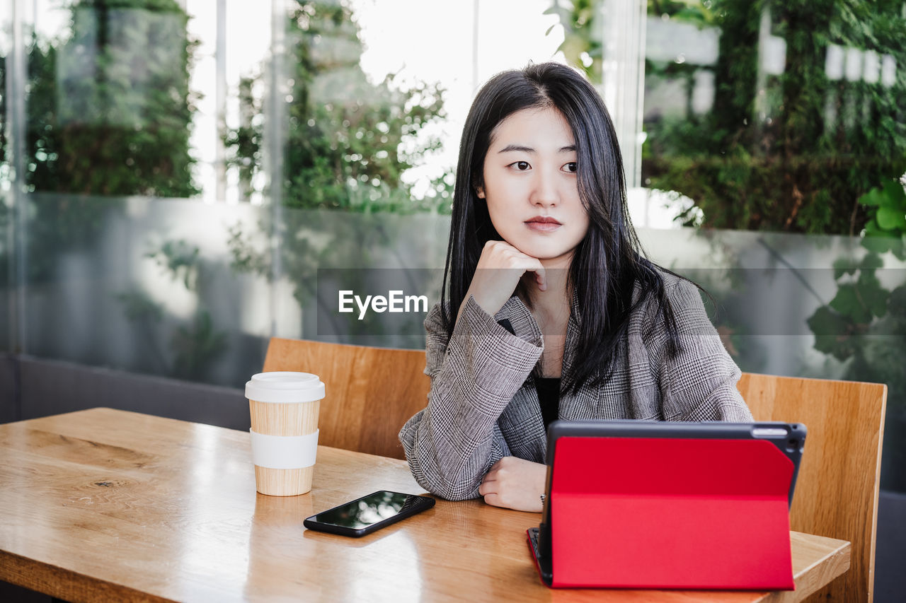 Professional chinese entrepreneur woman working on laptop in cafeteria. technology, lifestyle