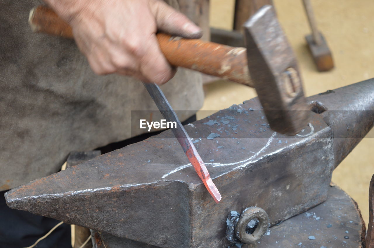 Cropped hand of manual worker holding hammer