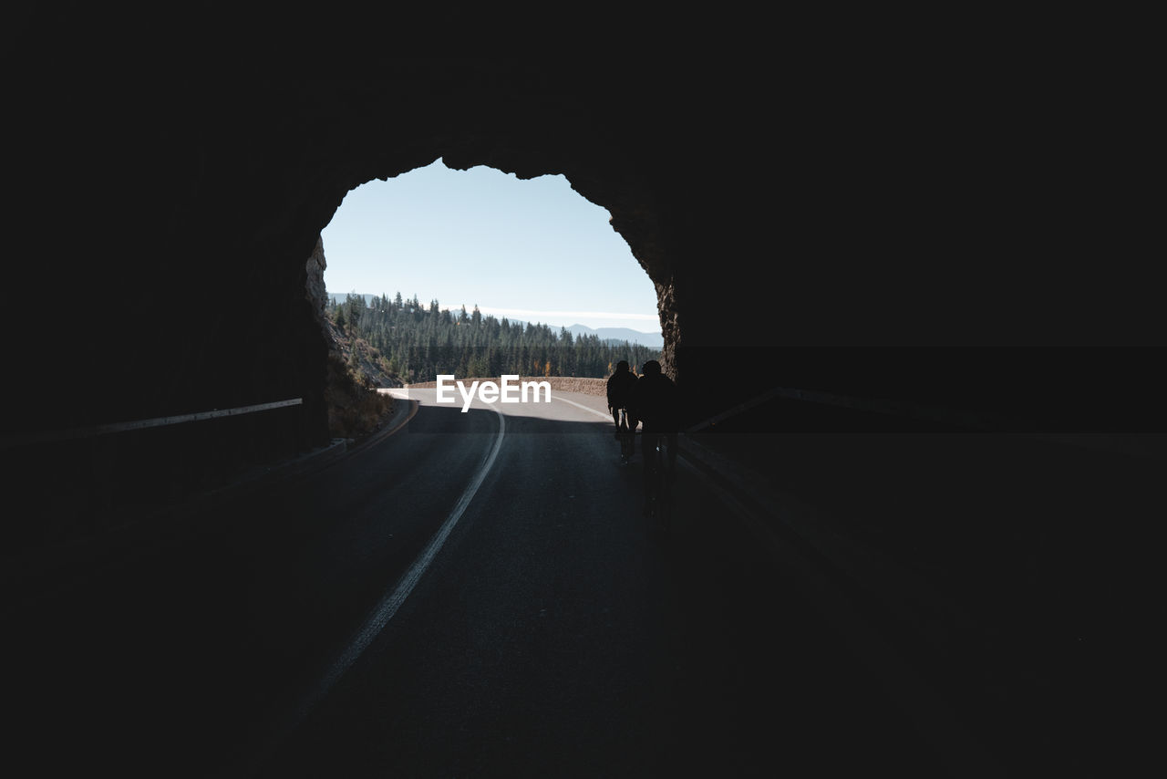 Cyclist ride through tunnel in forest