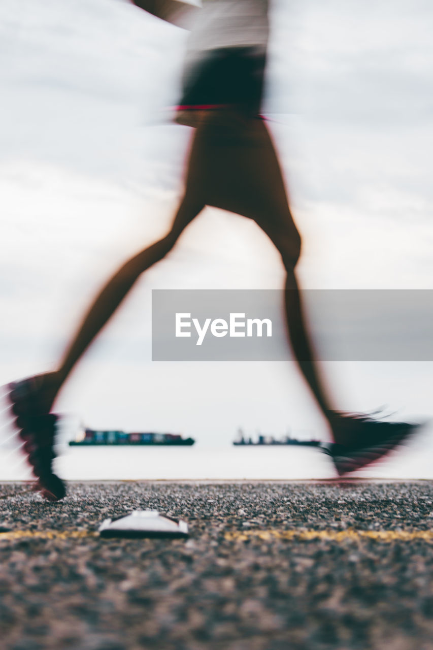 Low section of man running on road