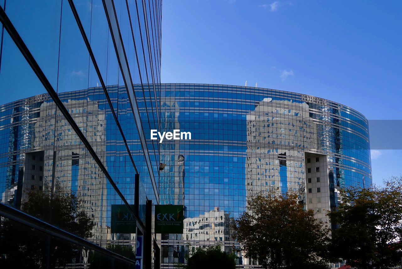 LOW ANGLE VIEW OF MODERN SKYSCRAPER AGAINST BLUE SKY