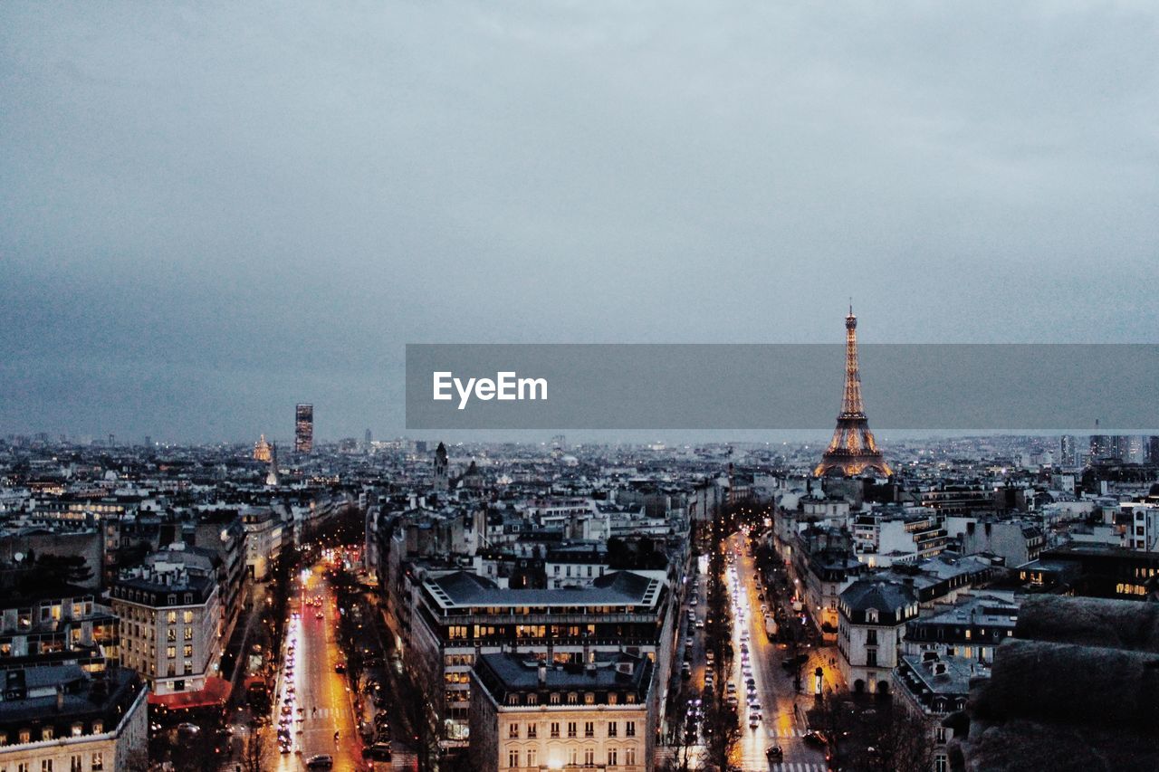 HIGH ANGLE VIEW OF BUILDINGS IN CITY AGAINST CLOUDY SKY