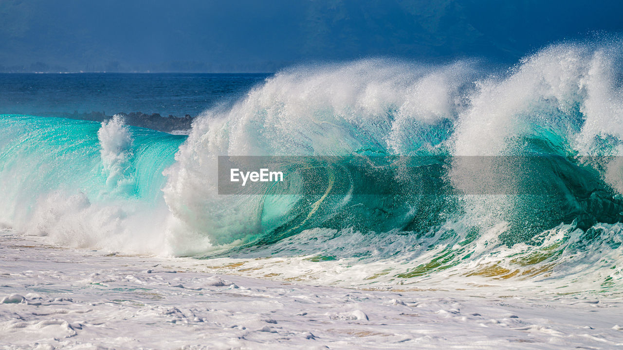 High resolution photo of waves crashing against the shore