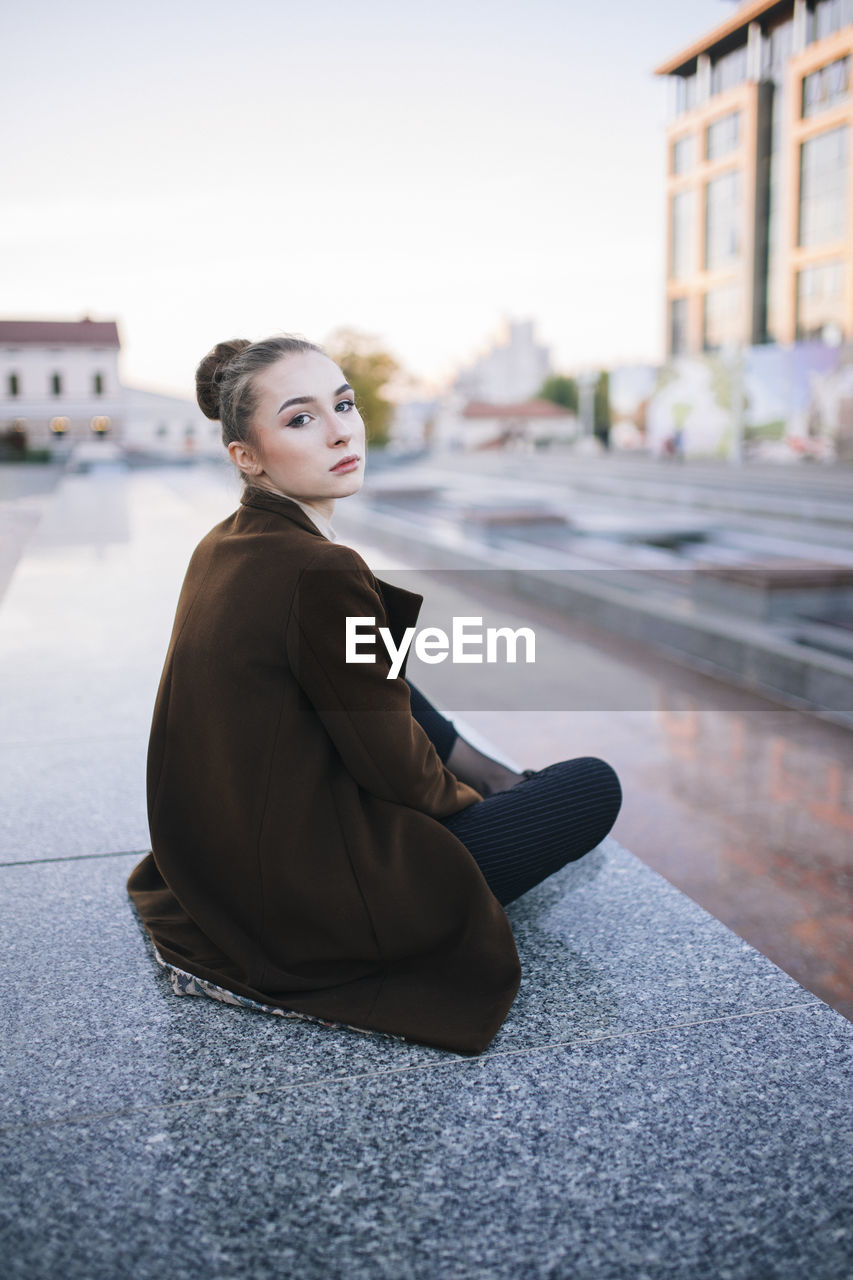 Woman sitting in the city on a marble tile