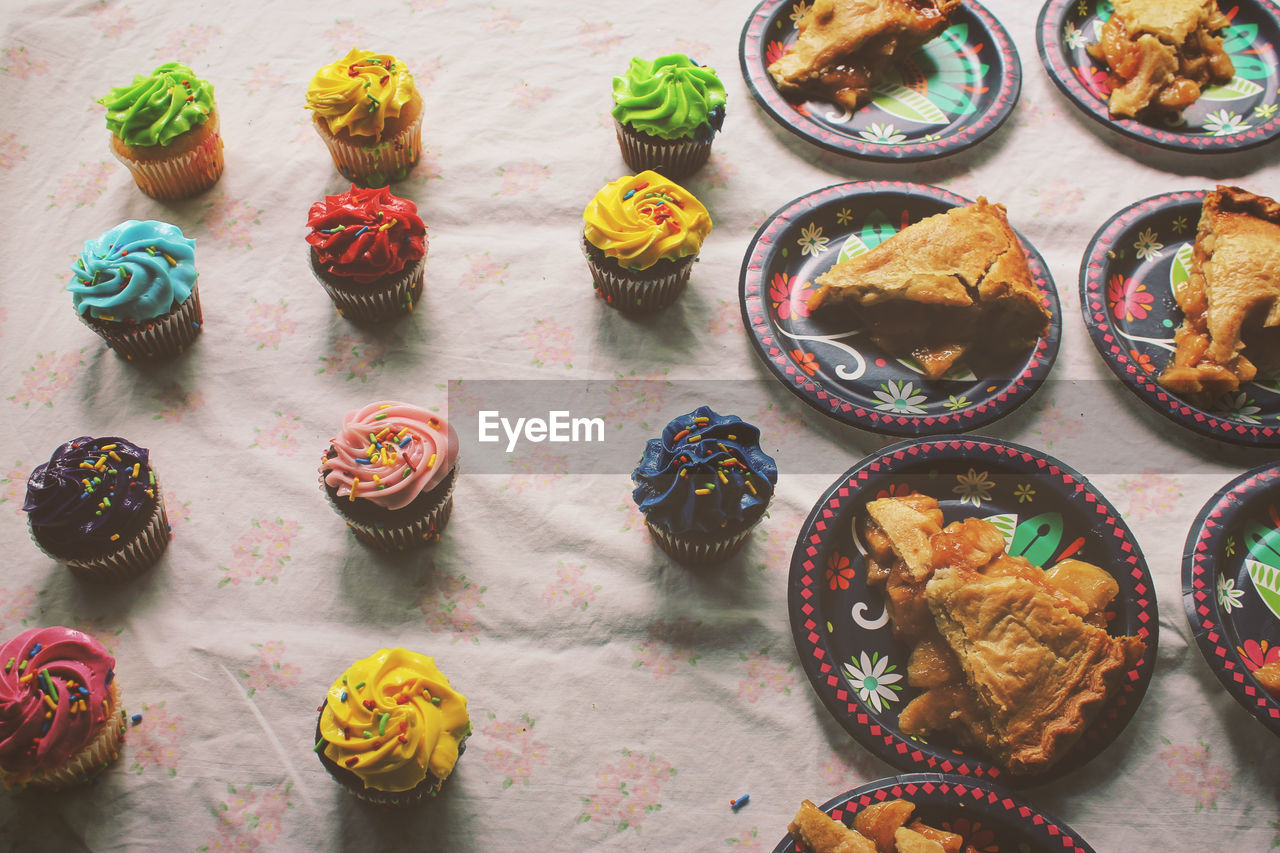 High angle view of apple pies and cupcakes on table