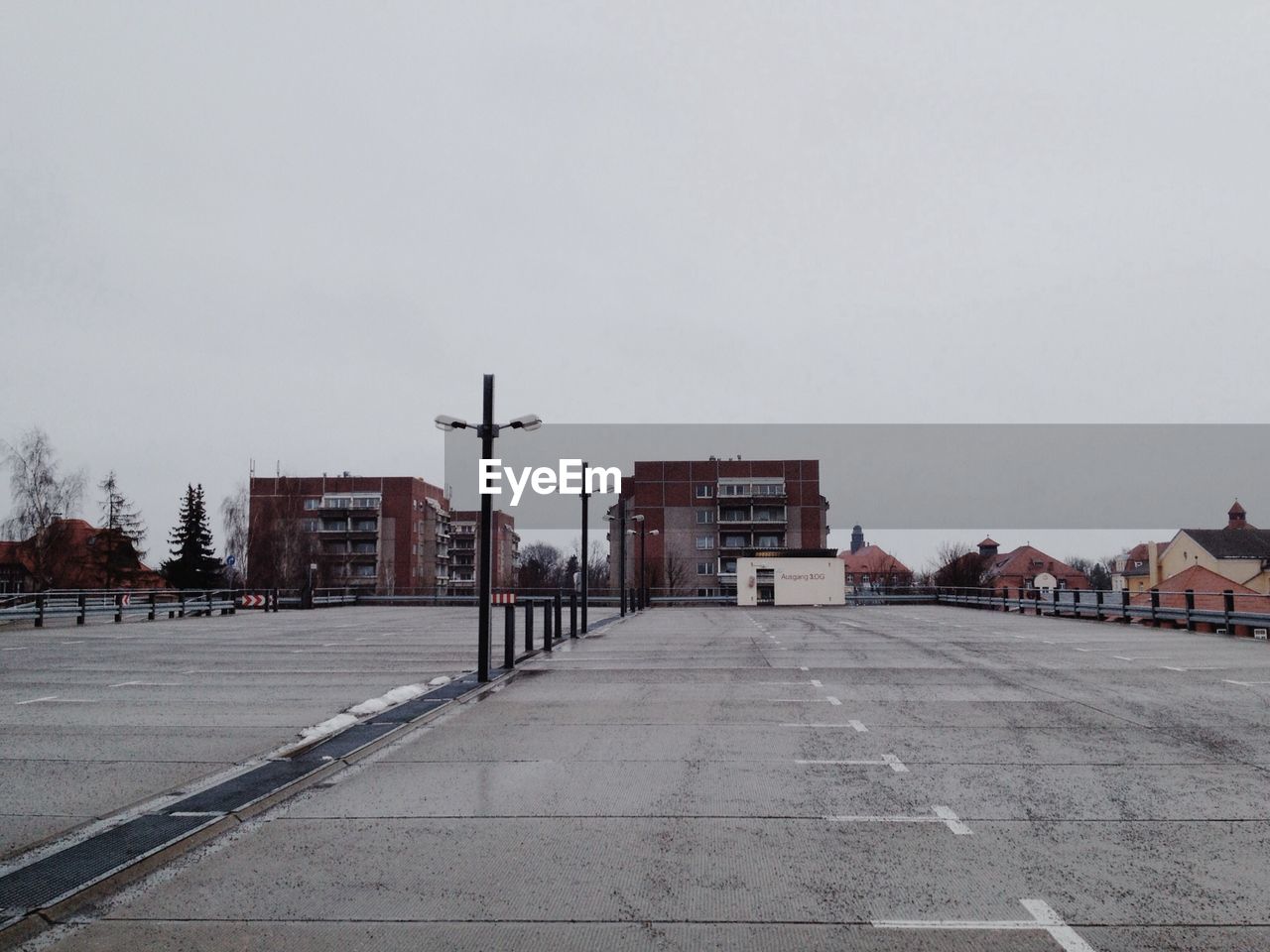 Empty parking lot and buildings against clear sky