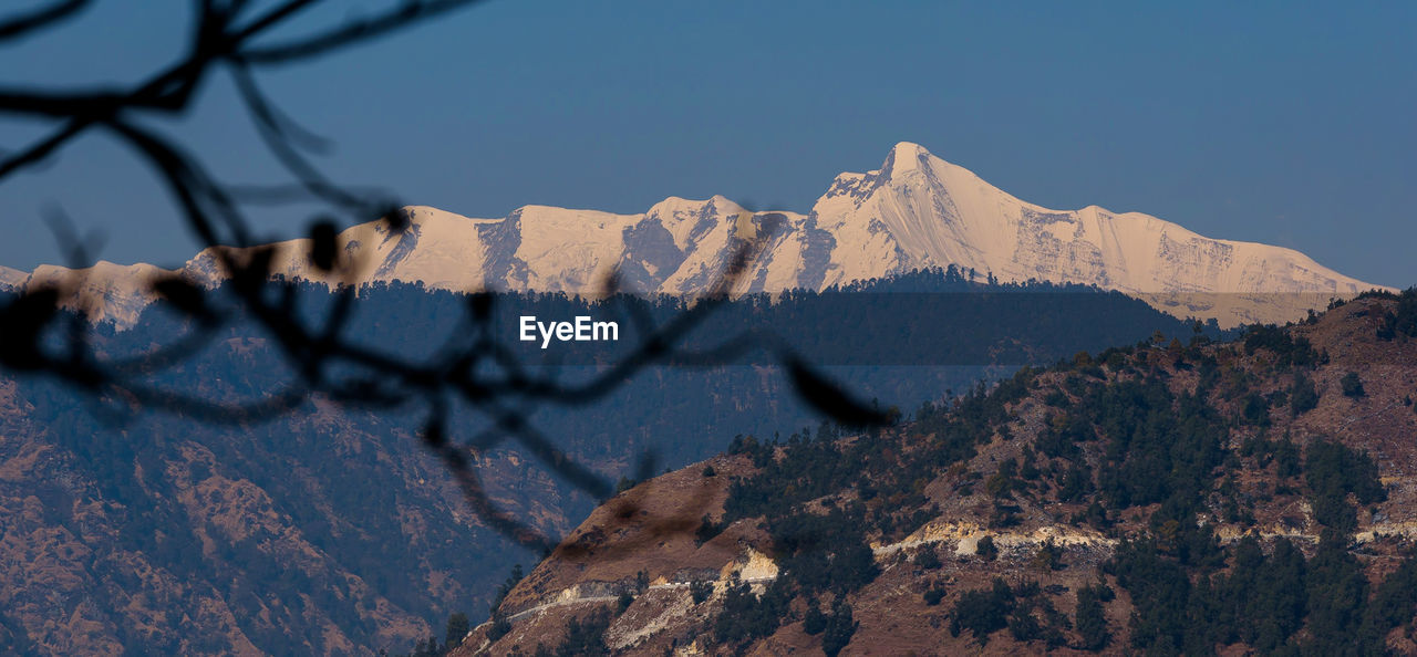 nature, mountain, scenics - nature, sky, beauty in nature, wilderness, mountain range, landscape, snow, environment, no people, winter, tree, land, rock, travel destinations, plant, outdoors, tranquility, cold temperature, non-urban scene, mountain peak, day, clear sky, tranquil scene, travel, summit, sunlight, snowcapped mountain