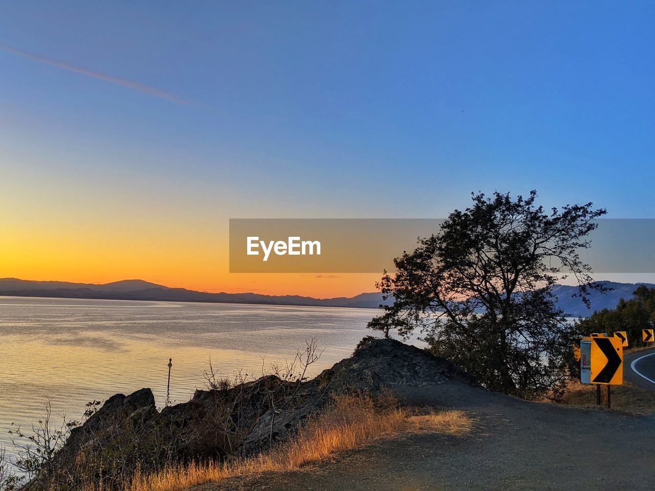 SCENIC VIEW OF BEACH AGAINST CLEAR SKY AT SUNSET