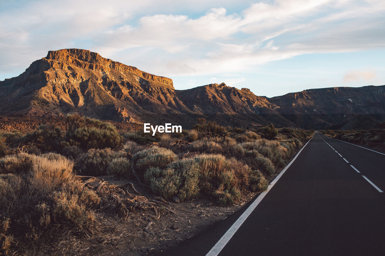 Road by mountain against sky