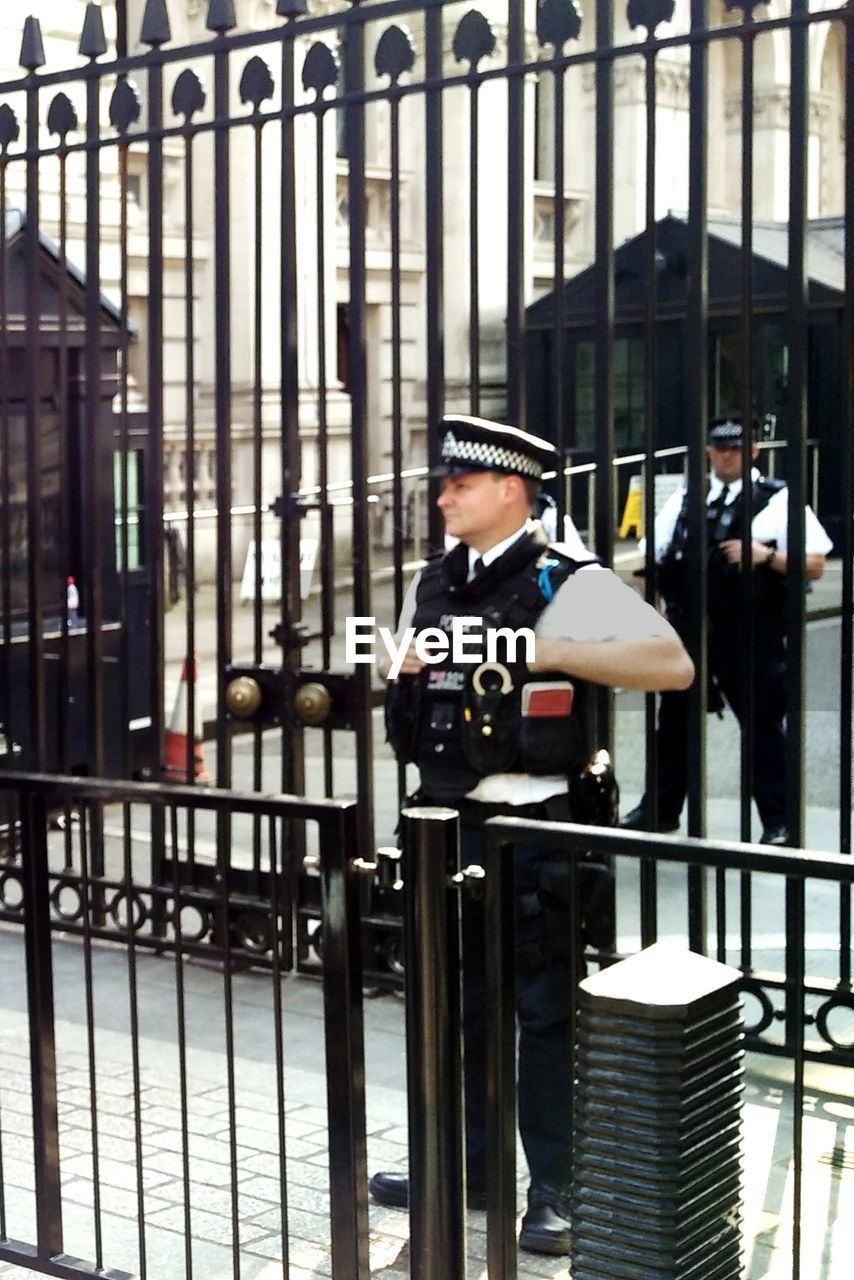 REAR VIEW OF MAN STANDING AT RAILING