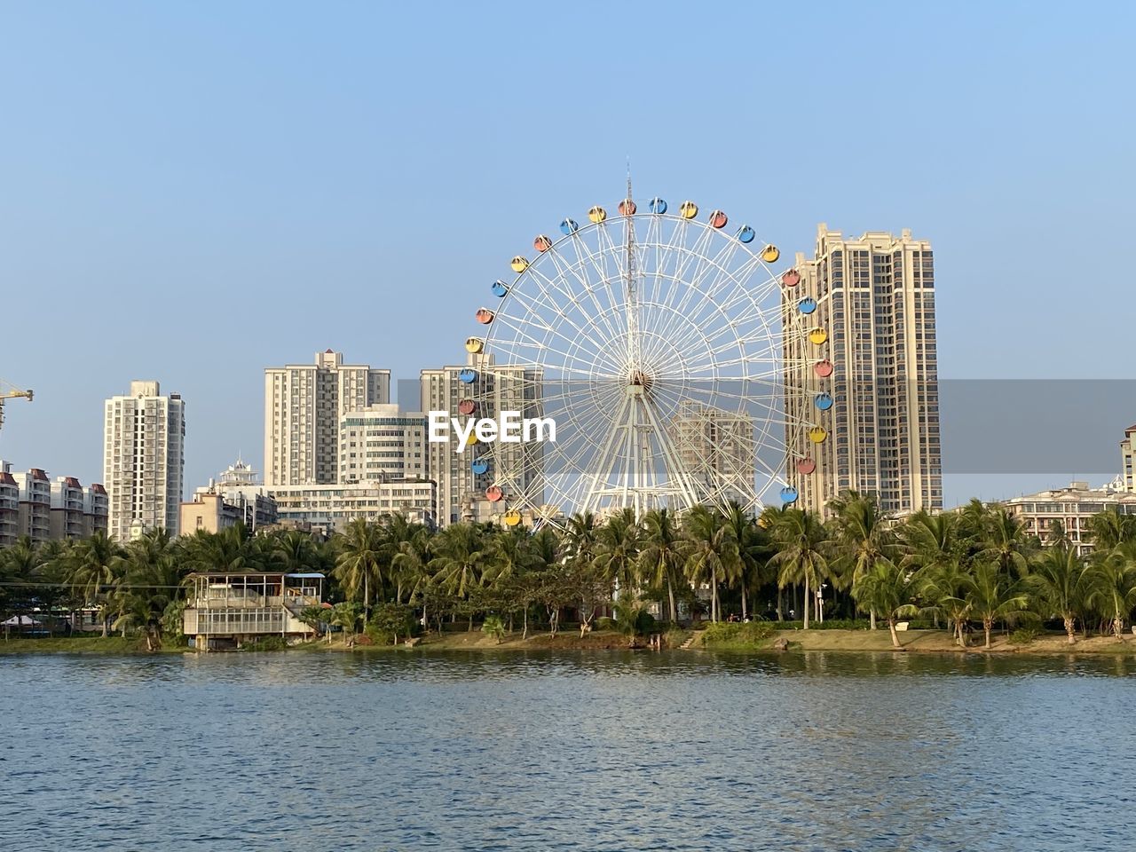 FERRIS WHEEL AND BUILDINGS AGAINST SKY