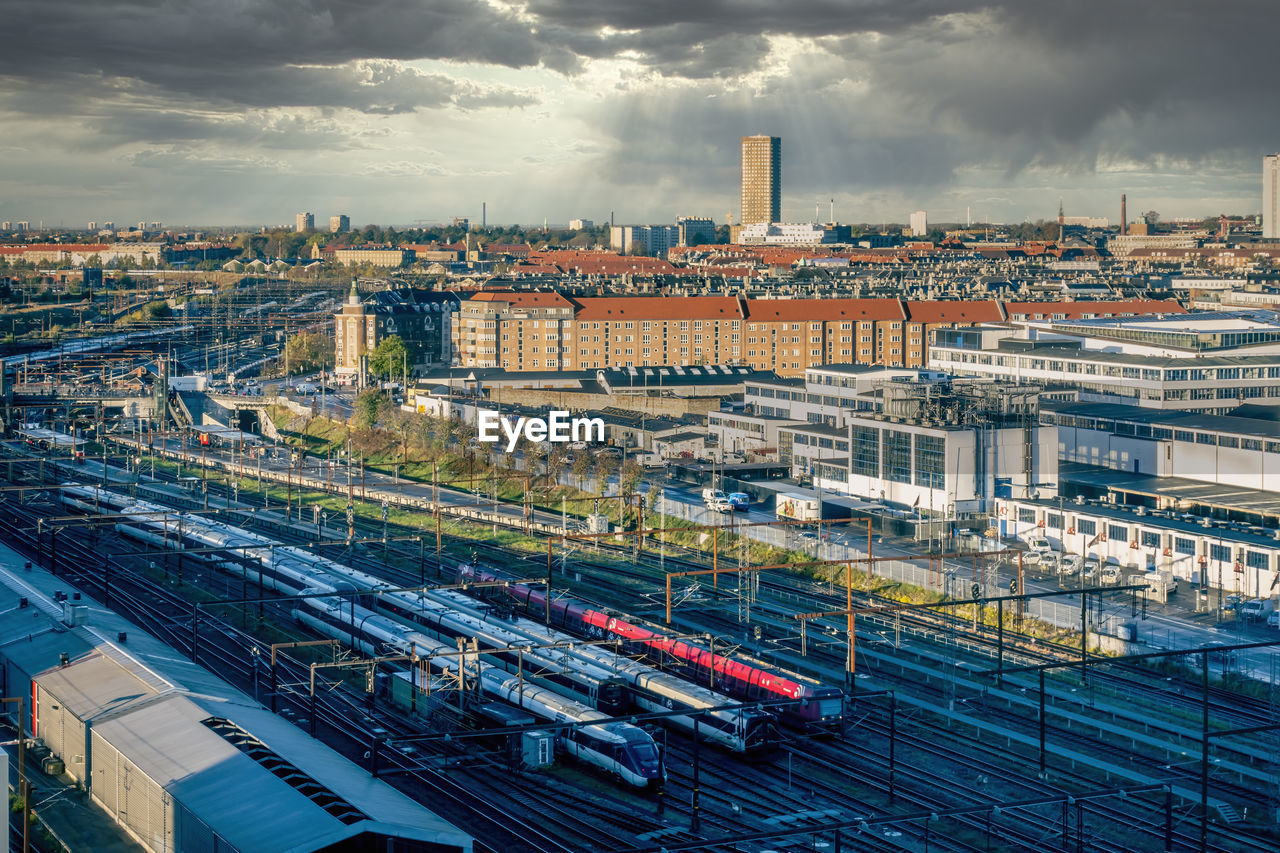 Morning view of the copenhagen city skyline from an elevated vantage point. trains in foreground.