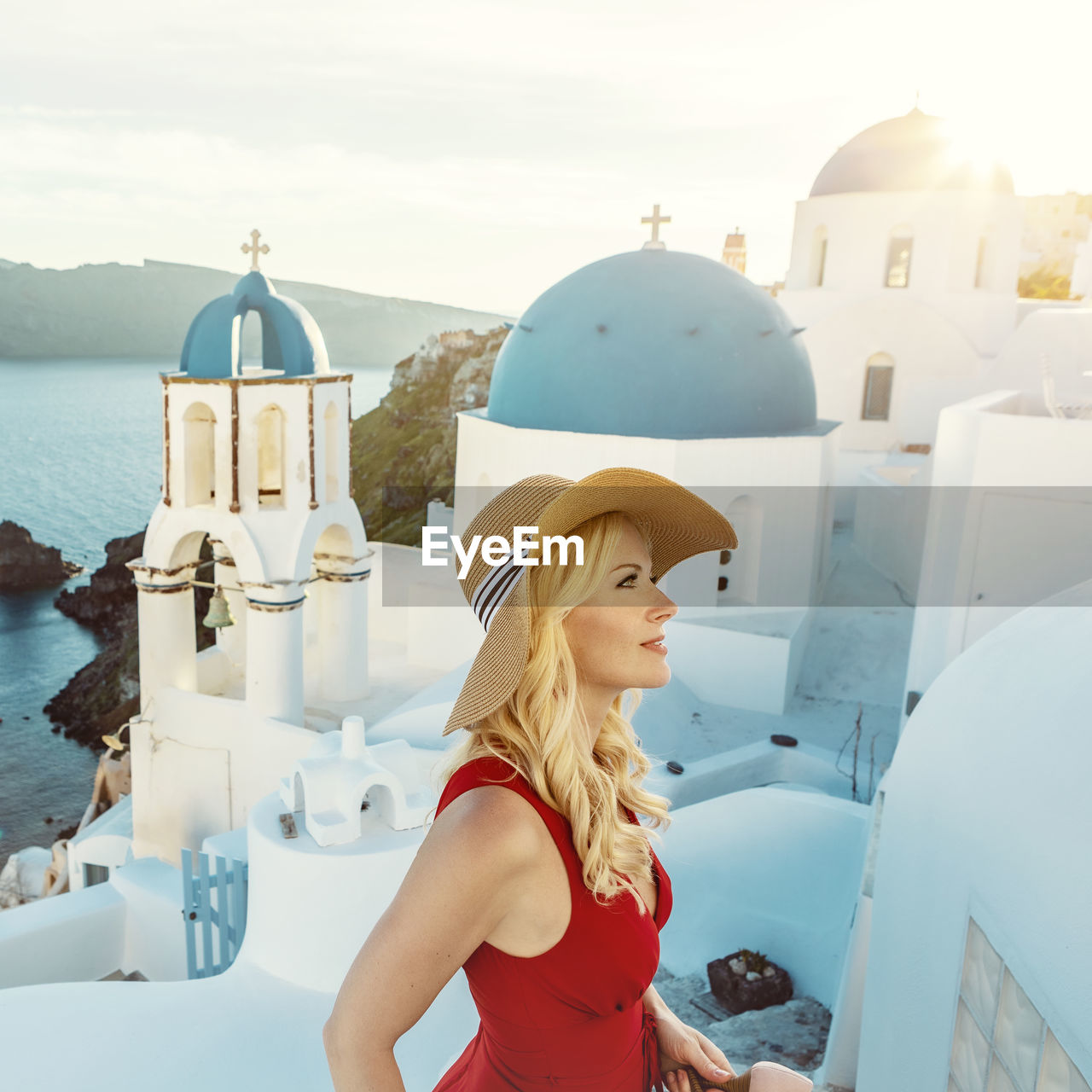 Woman wearing hat standing against buildings in city