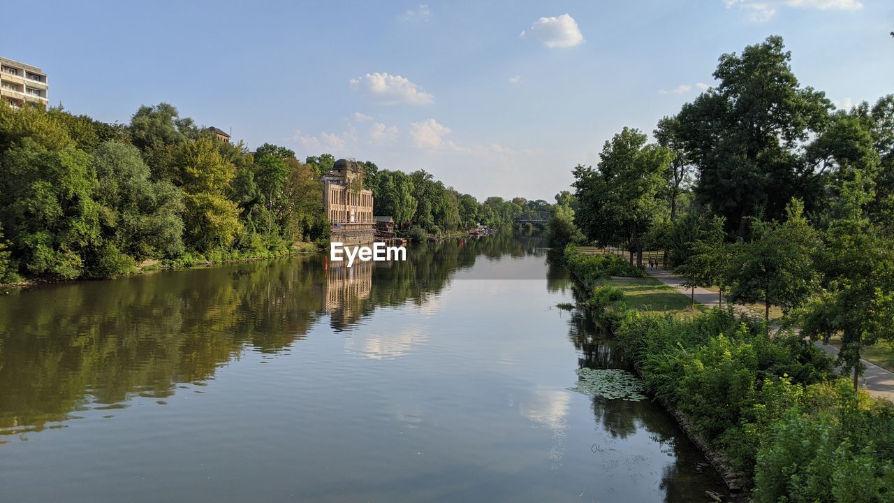 Scenic view of river by trees against sky