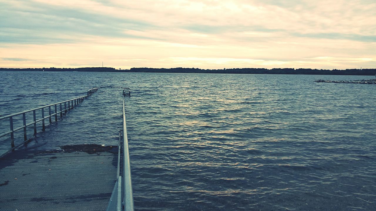 Long jetty leading to calm blue sea