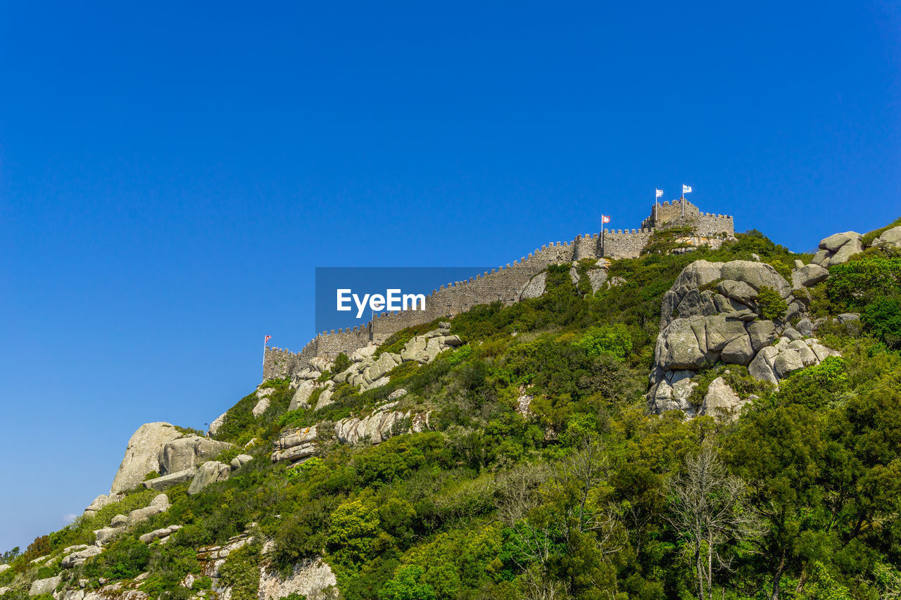 LOW ANGLE VIEW OF ROCKS AGAINST BLUE SKY