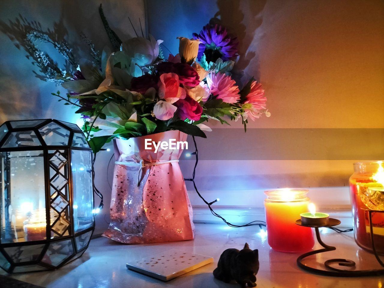 flower, flowering plant, plant, vase, nature, table, candle, beauty in nature, centrepiece, indoors, no people, flower arrangement, freshness, decoration, arrangement, still life, home interior, multi colored, furniture, bouquet, illuminated, lighting equipment