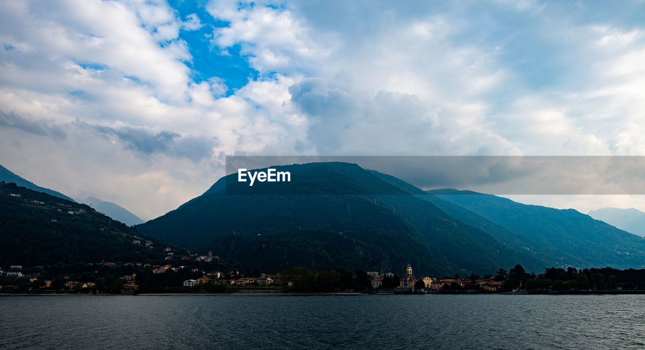 Scenic view of lake by mountains against sky