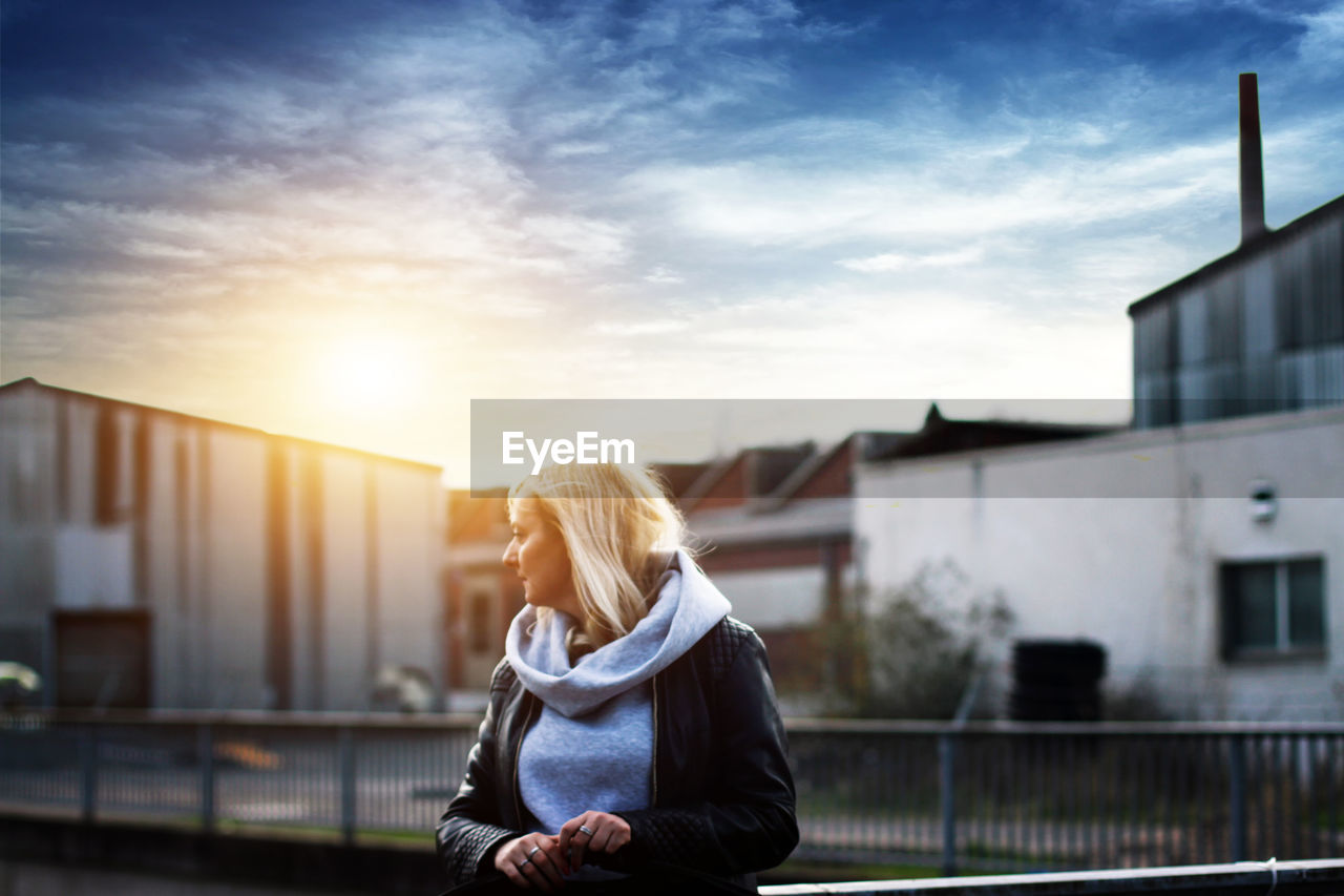 Woman standing against sky during sunset