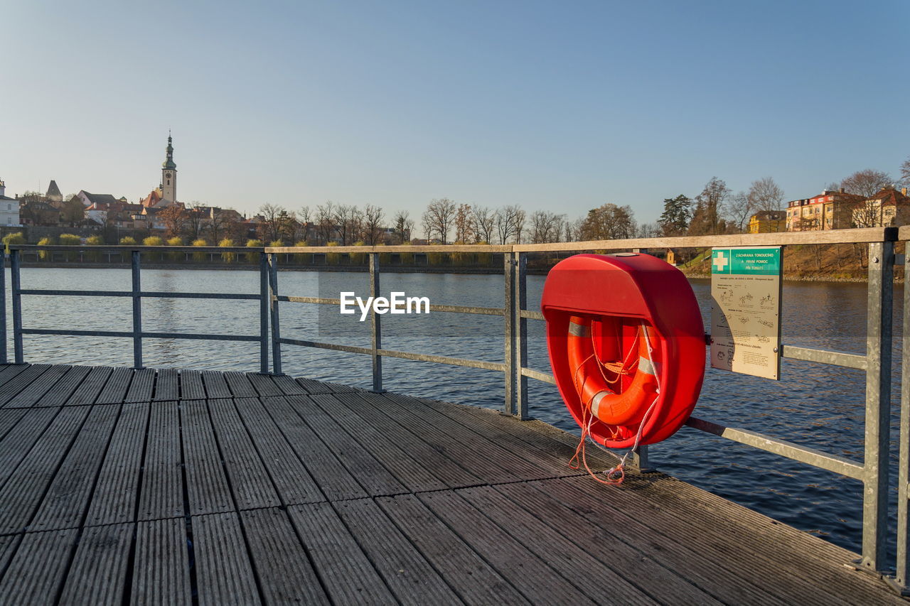 RED PIER BY RIVER AGAINST SKY