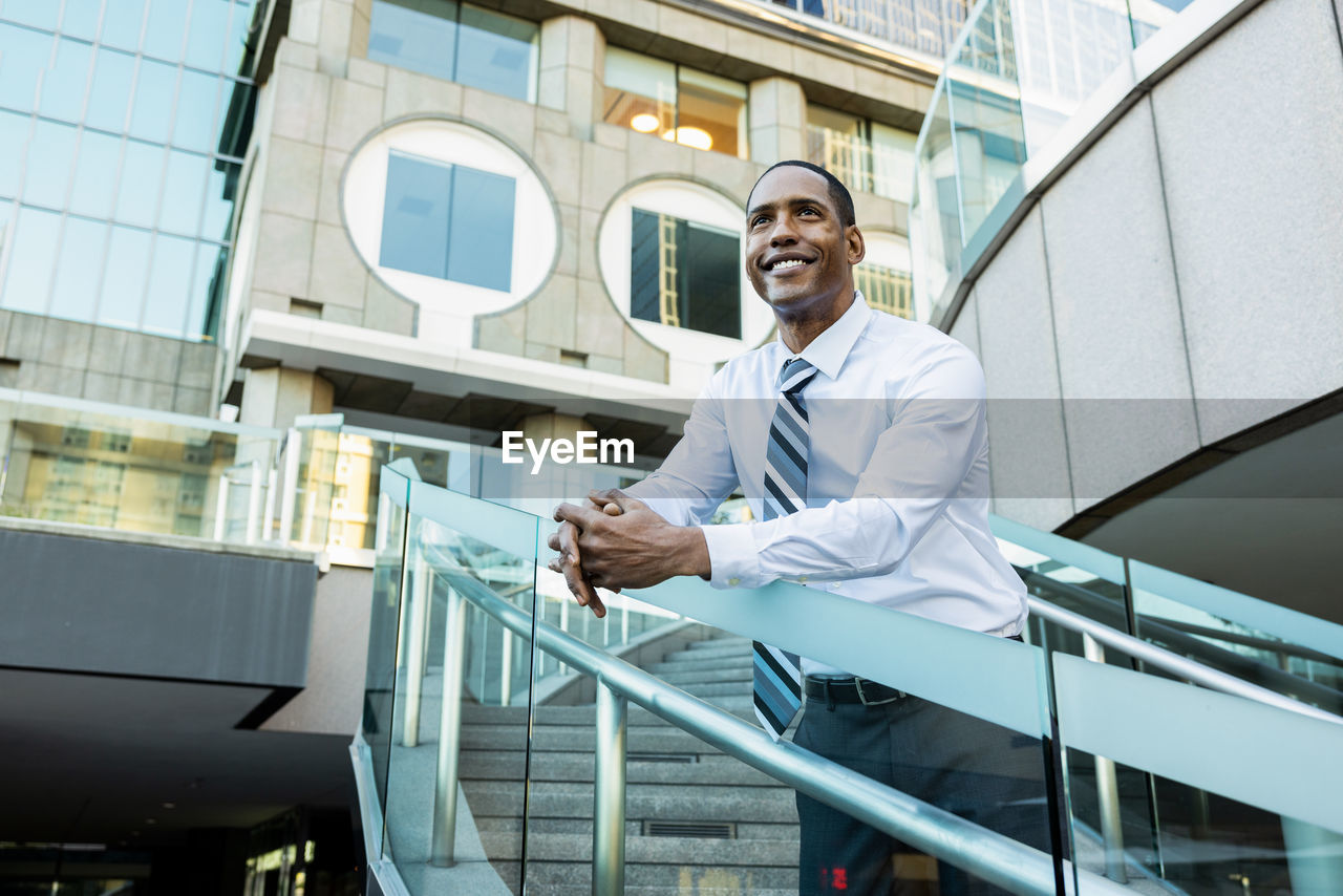 portrait of young man standing against building