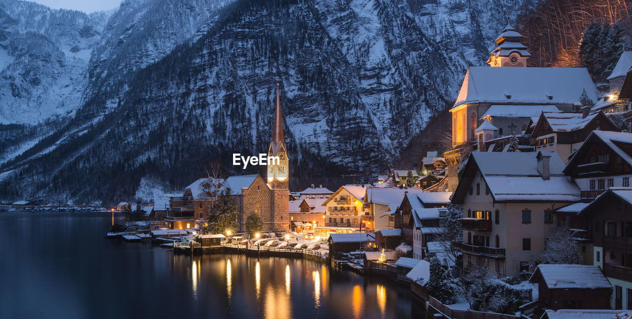 Buildings by lake during winter in hallstatt at dusk