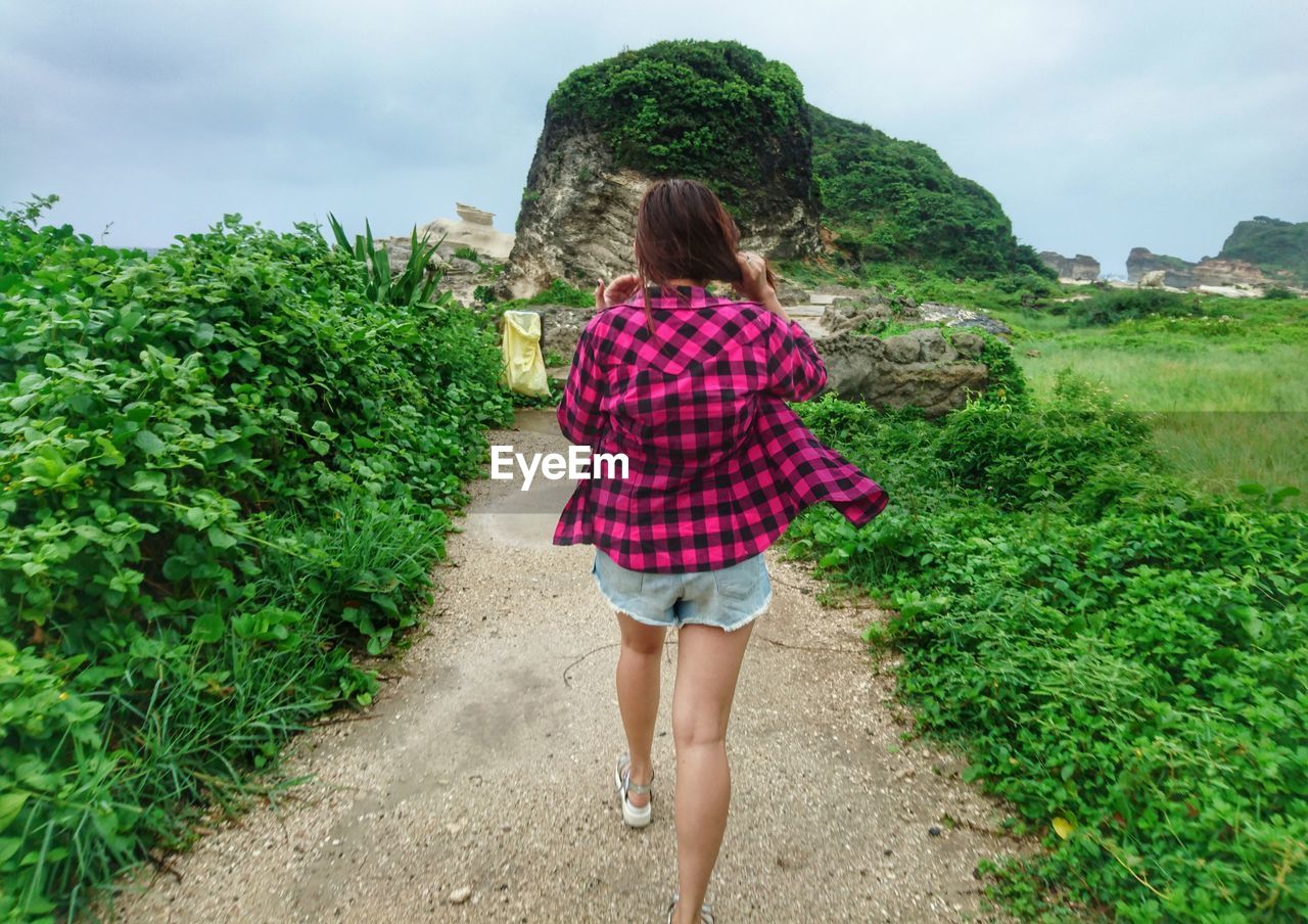 Rear view of woman walking on footpath