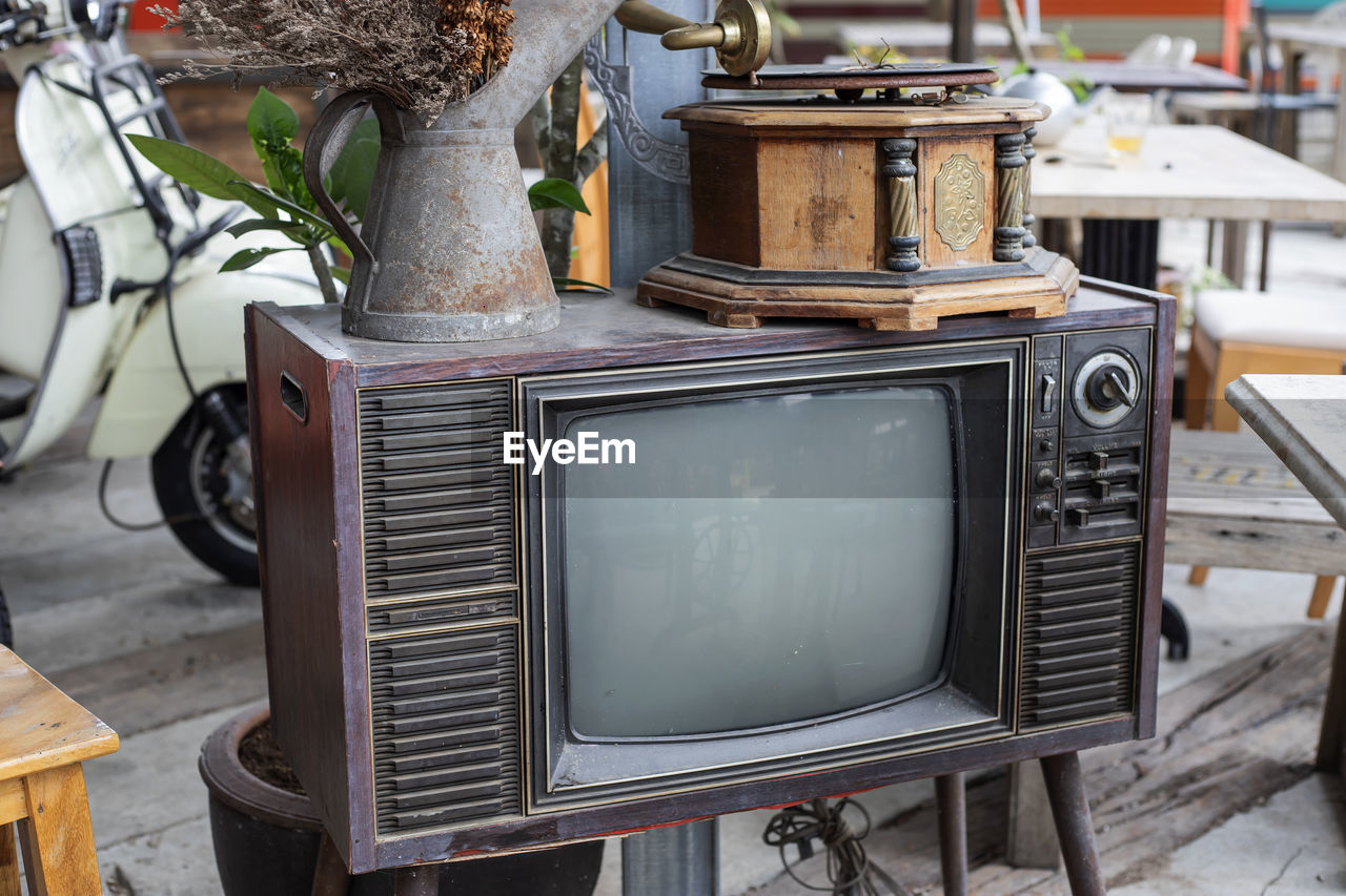 Close-up of old gramophone with vase on television set