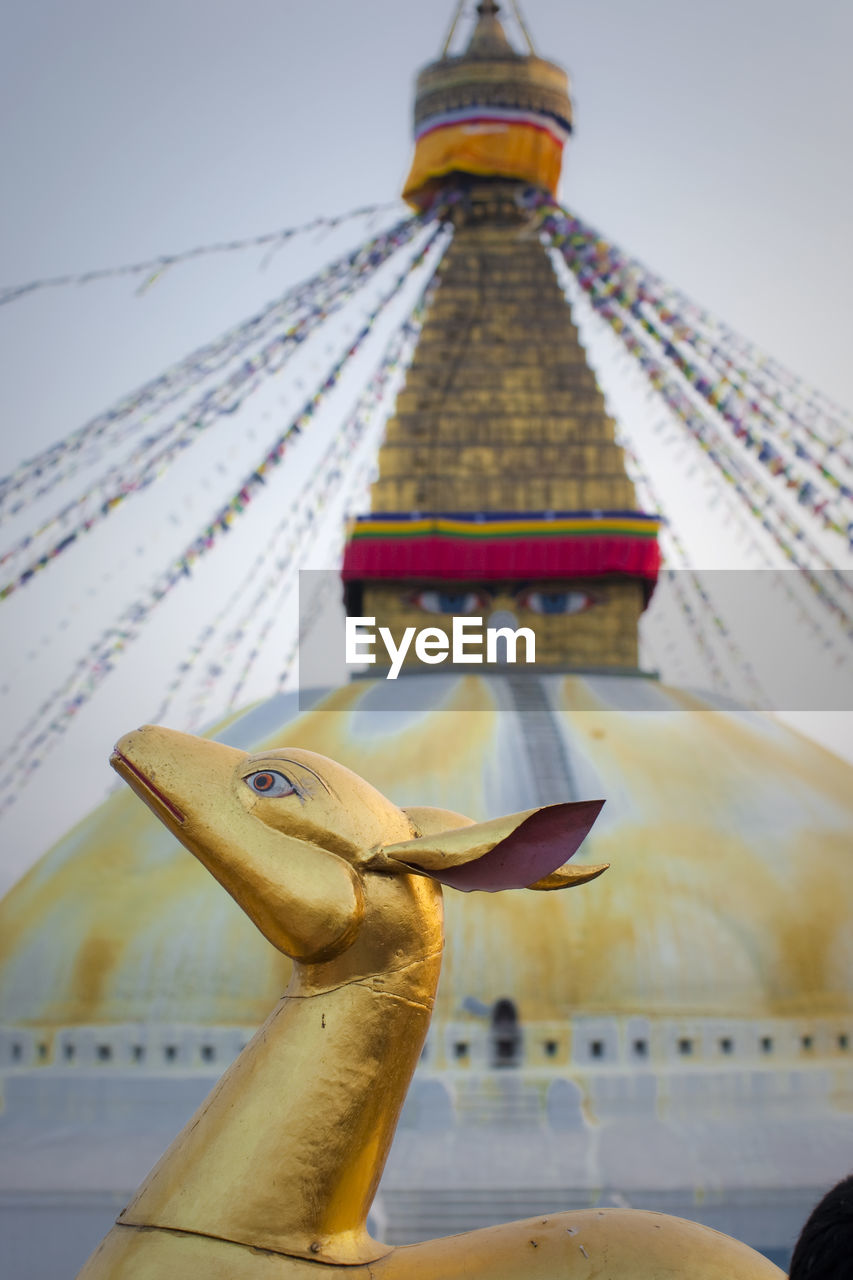 Nepal, bagmati province, kathmandu, gold colored animal sculpture at boudhanath stupa