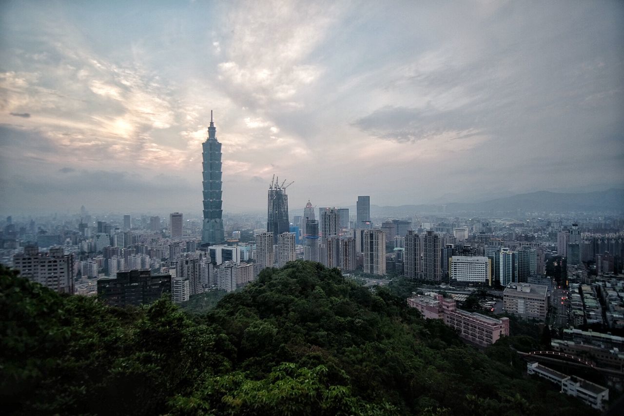 Taipei 101 in city against sky during sunset