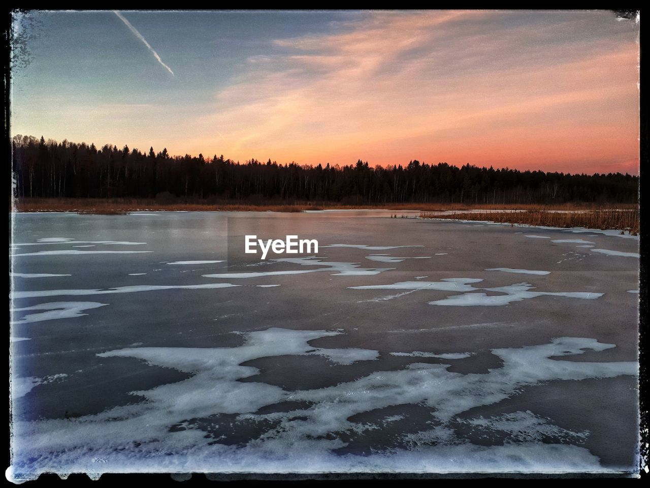 FROZEN LAKE AGAINST SKY DURING WINTER