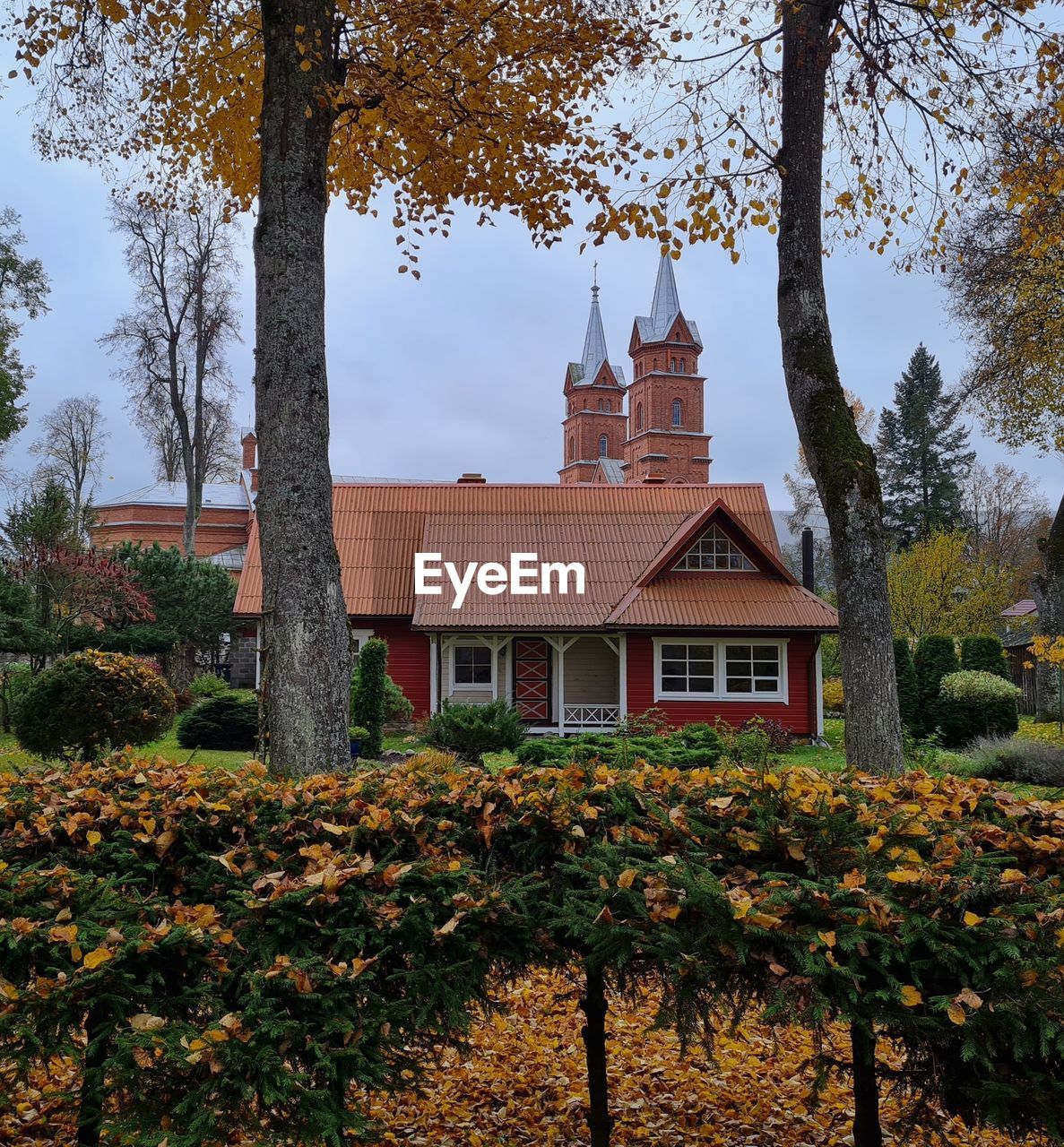 Countryside or village landscape with house and church in autumn