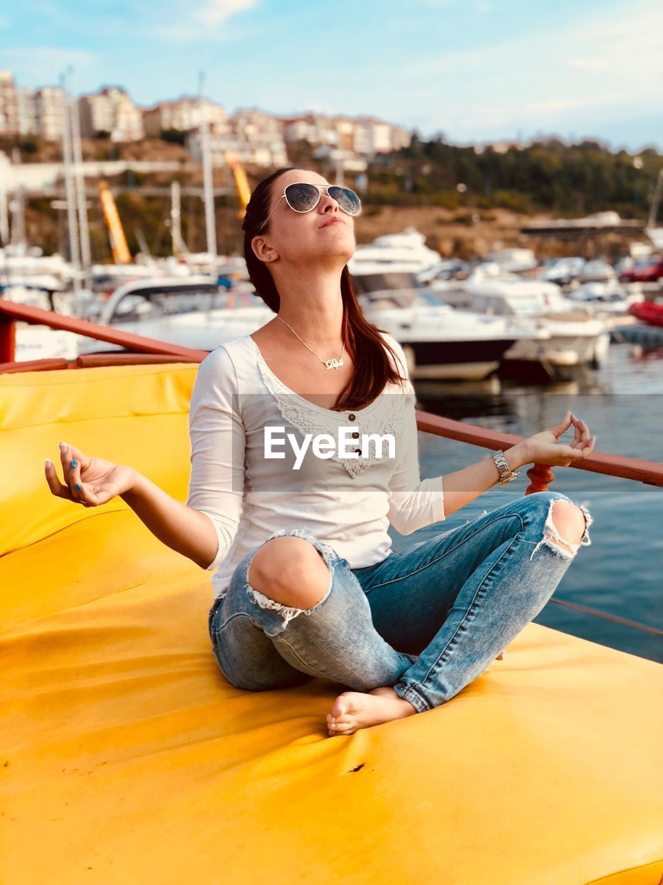 BEAUTIFUL YOUNG WOMAN SITTING ON BOAT