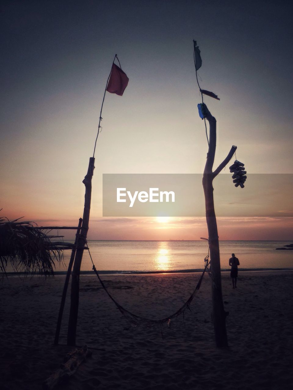 Silhouette of person and object on beach at sunset