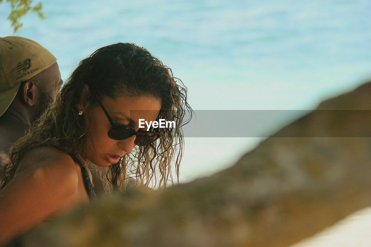 YOUNG WOMAN LOOKING AT BEACH