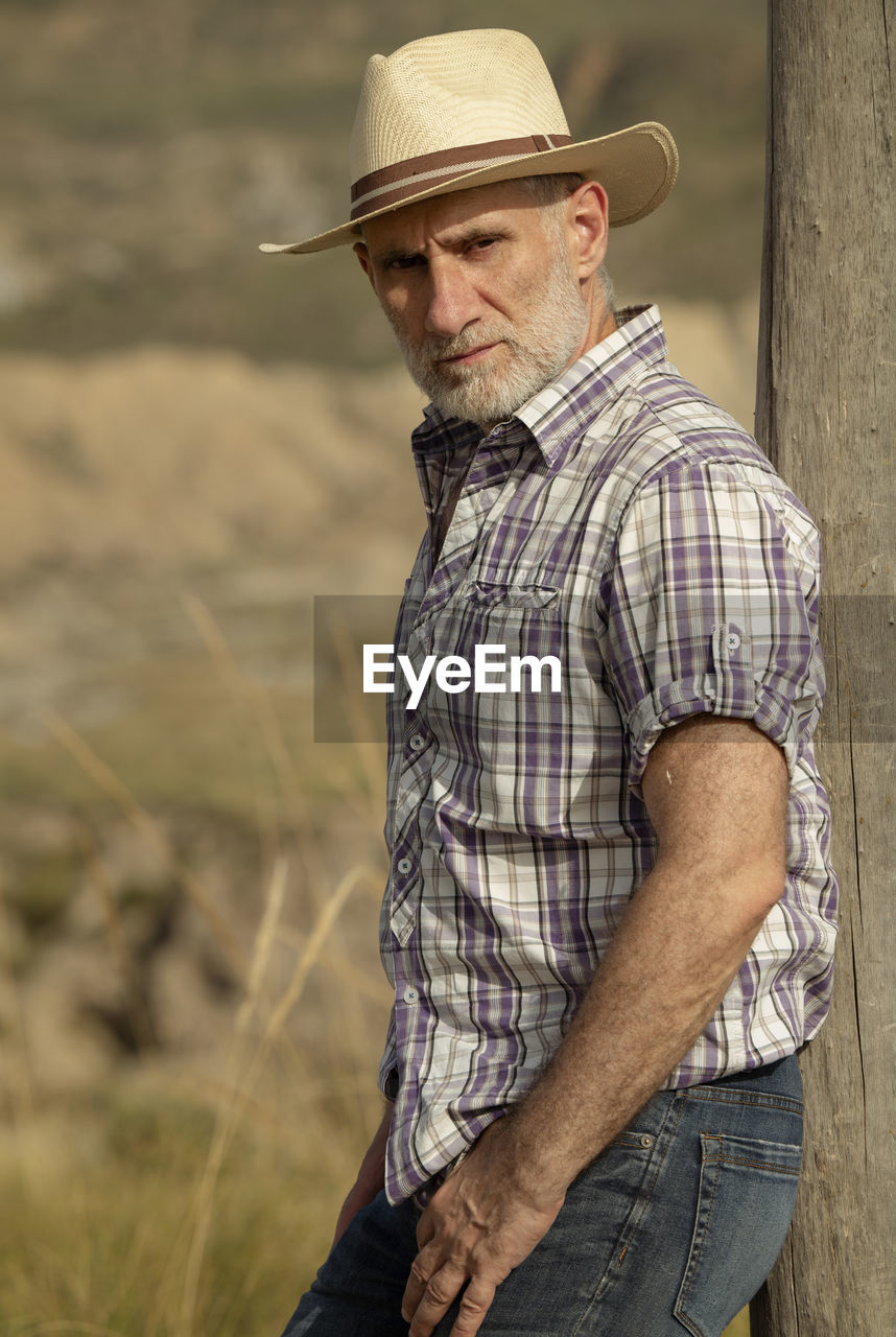 Portrait of adult man in sun hat and shirt in desert