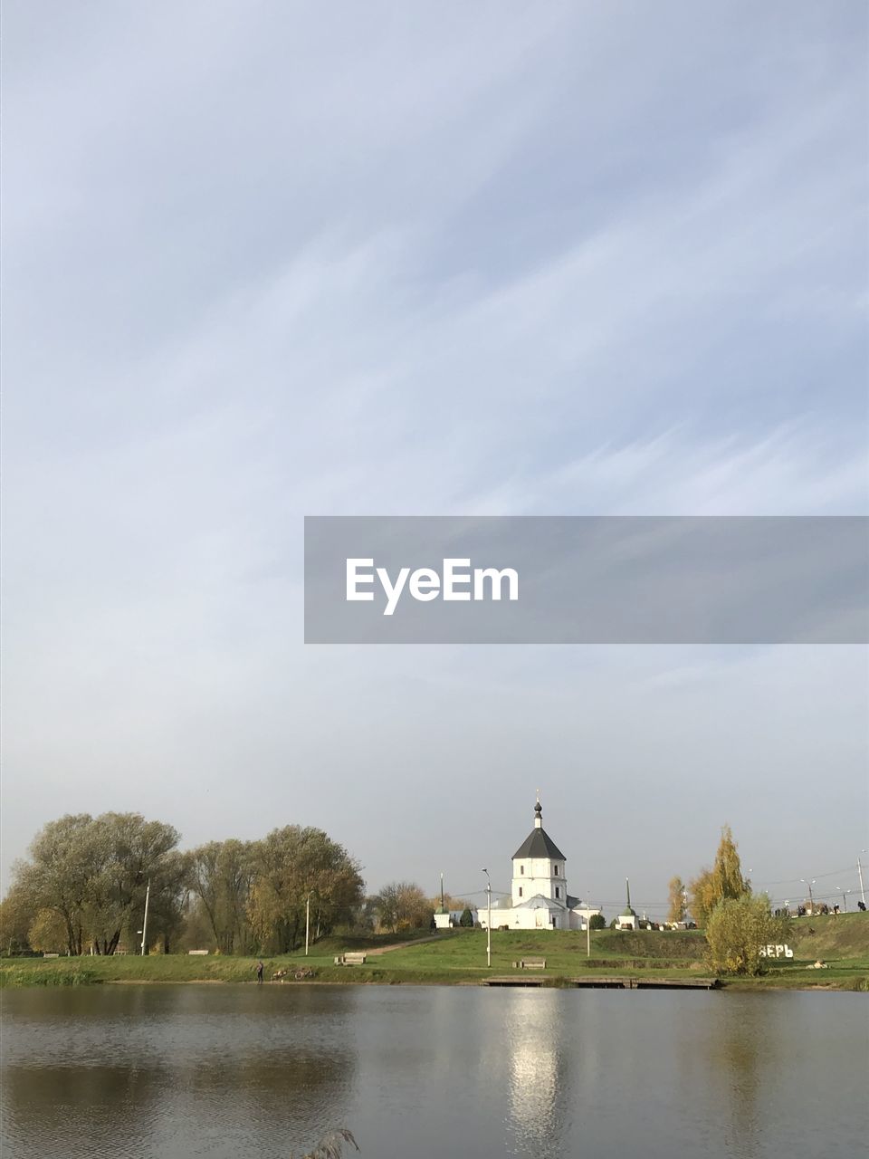 Scenic view of lake by a church against sky