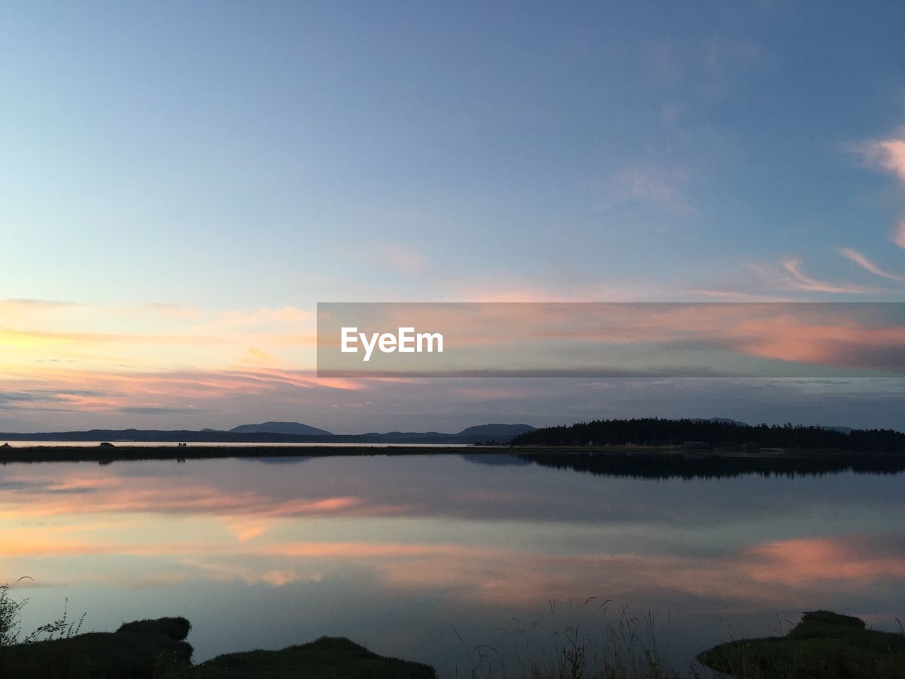 VIEW OF CALM LAKE AT SUNSET