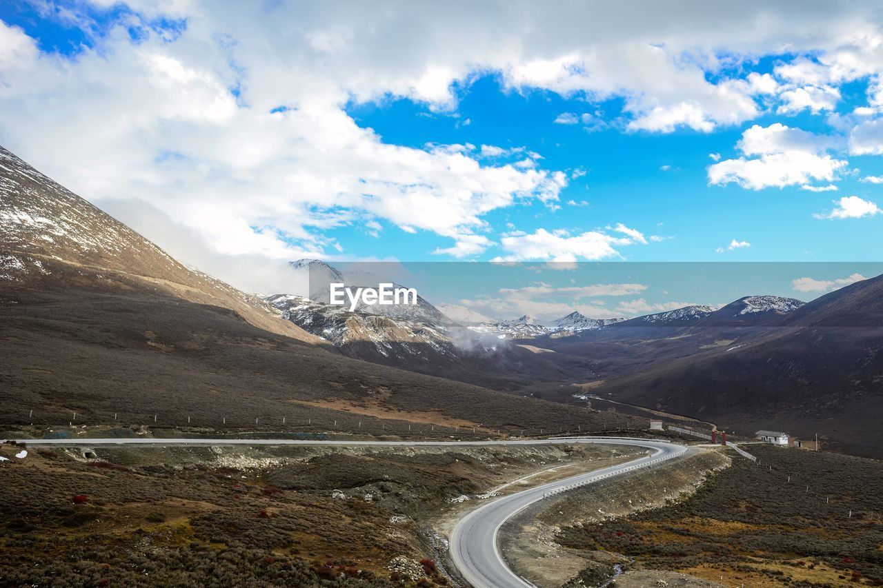 high angle view of road by mountains against sky