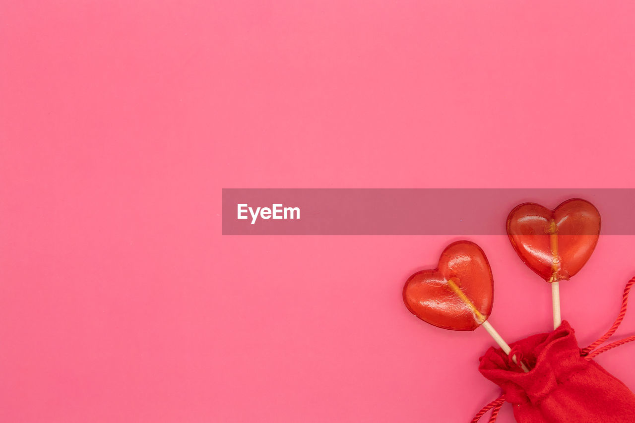 CLOSE-UP OF HEART SHAPE OVER PINK COLORED BACKGROUND