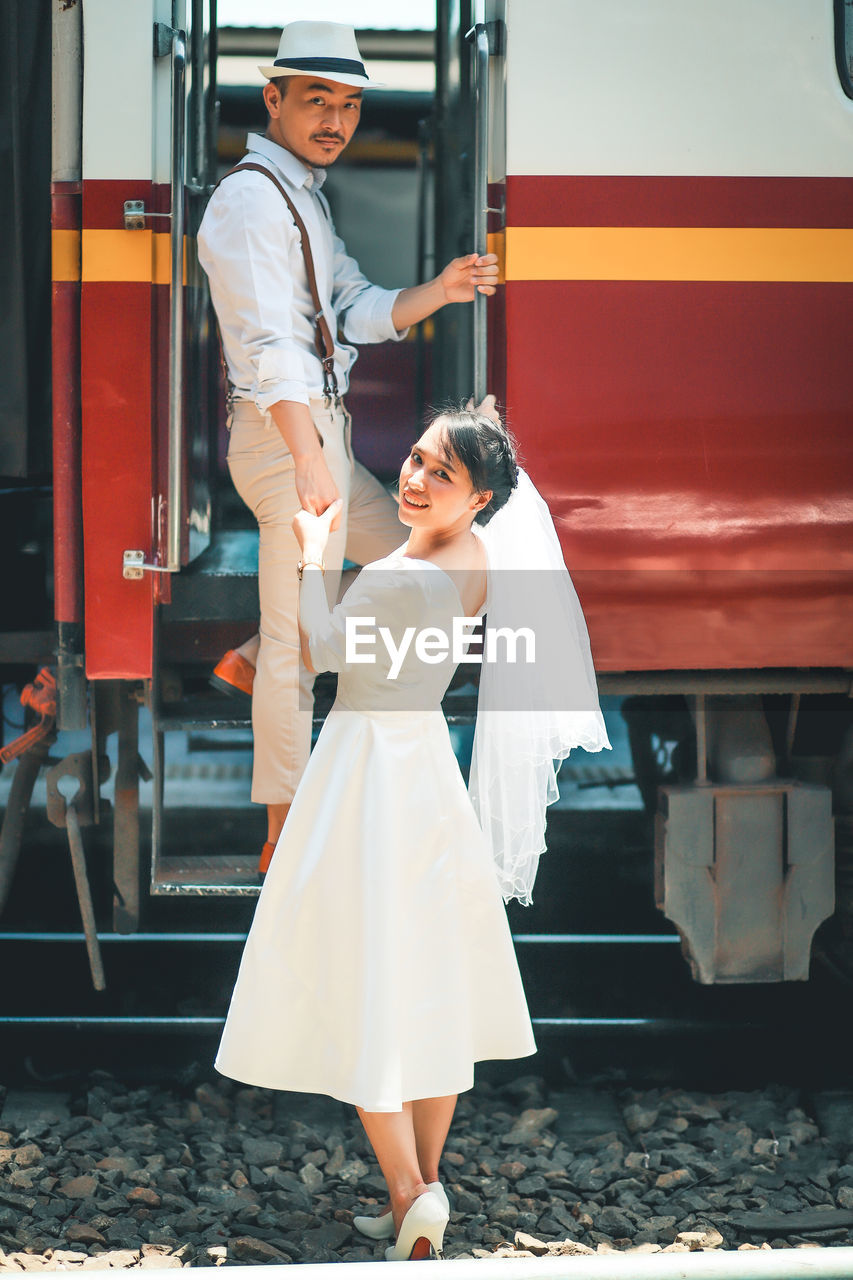 Wedding portrait of asian couple get into the train