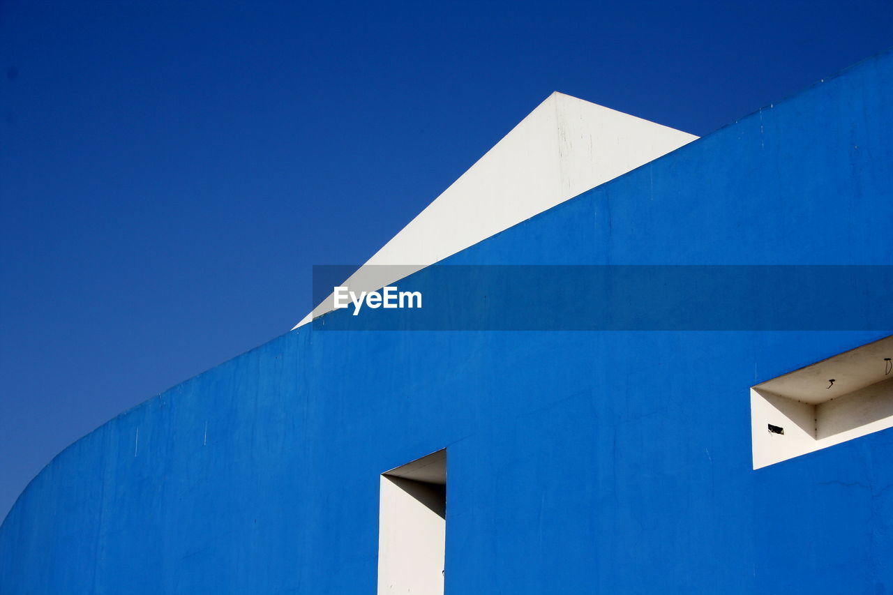 Low angle view of building against clear blue sky