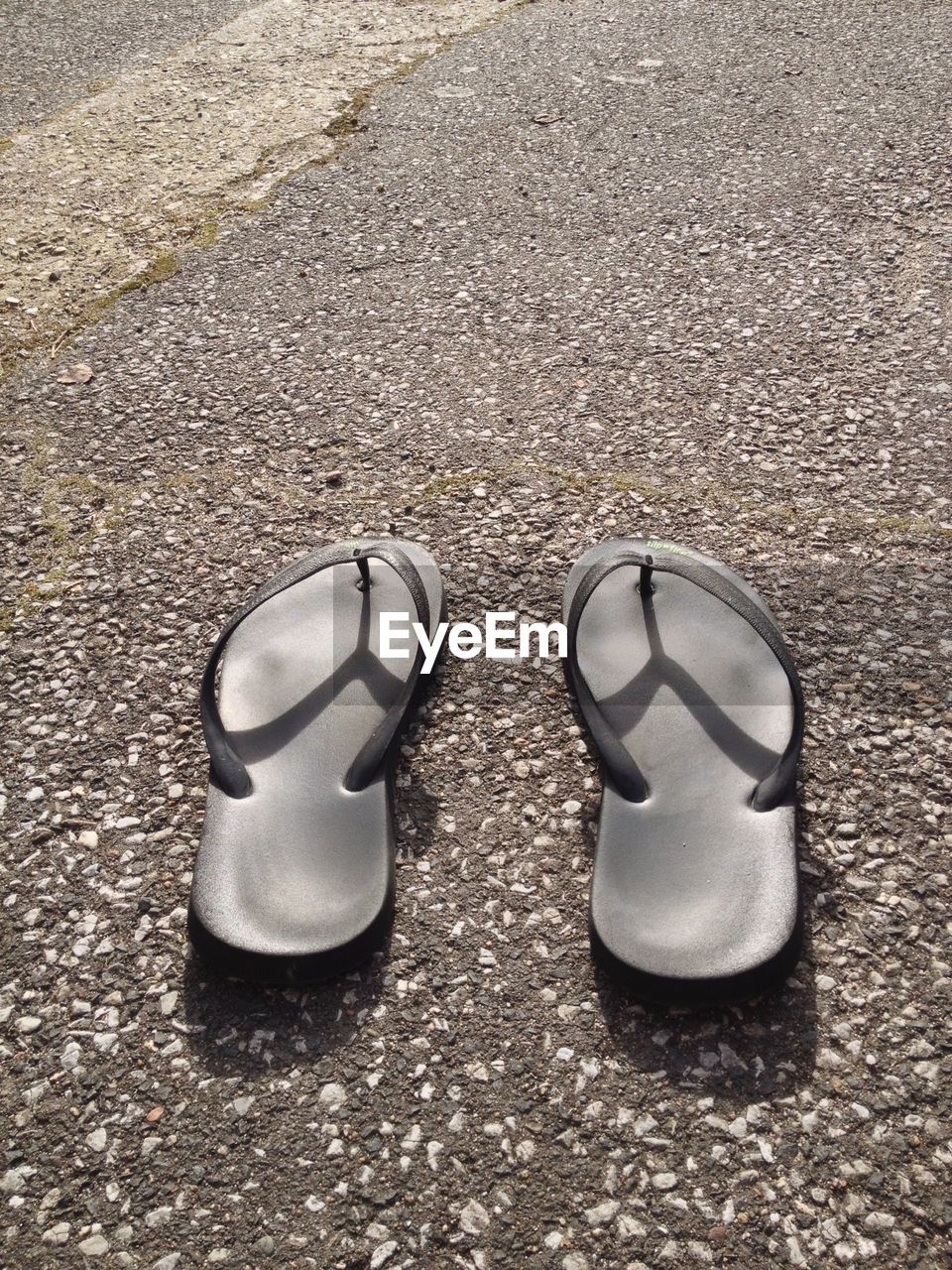 Pair of flip flops on road