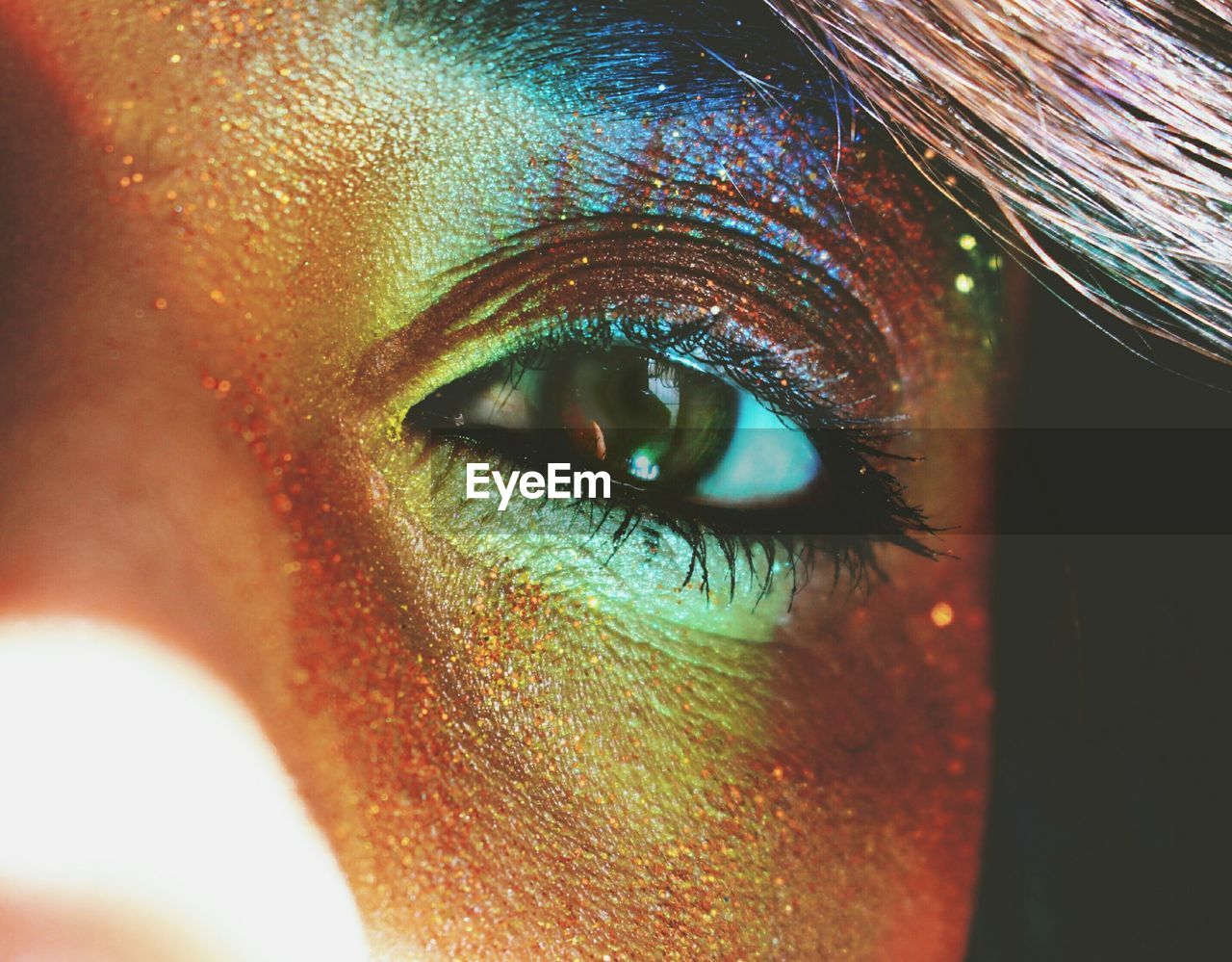 Cropped portrait of woman eye with colorful make-up