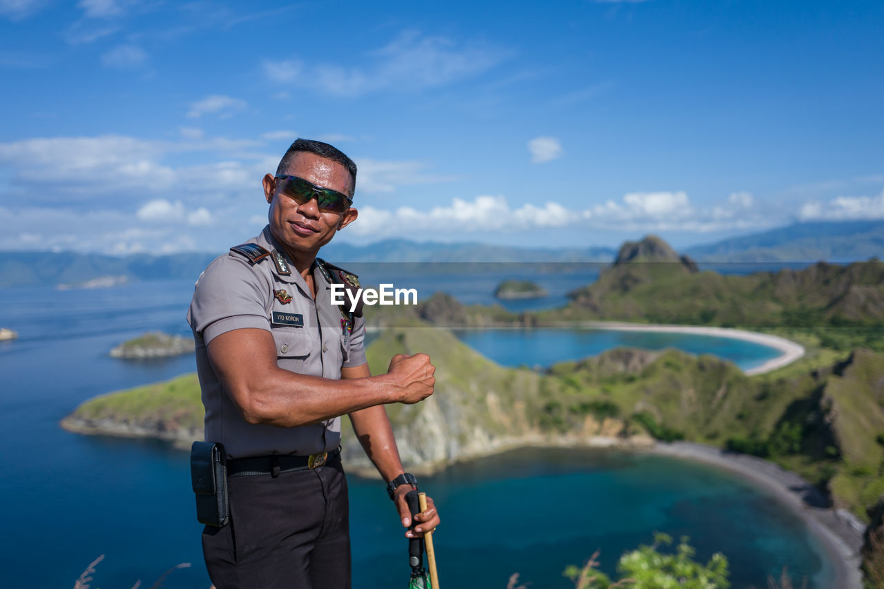 PORTRAIT OF YOUNG MAN STANDING AGAINST SEA