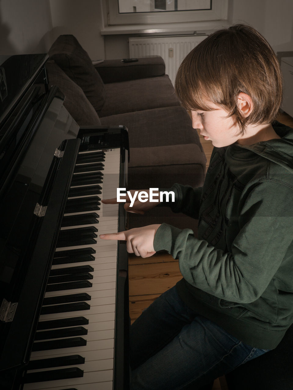 High angle view of boy playing piano at home