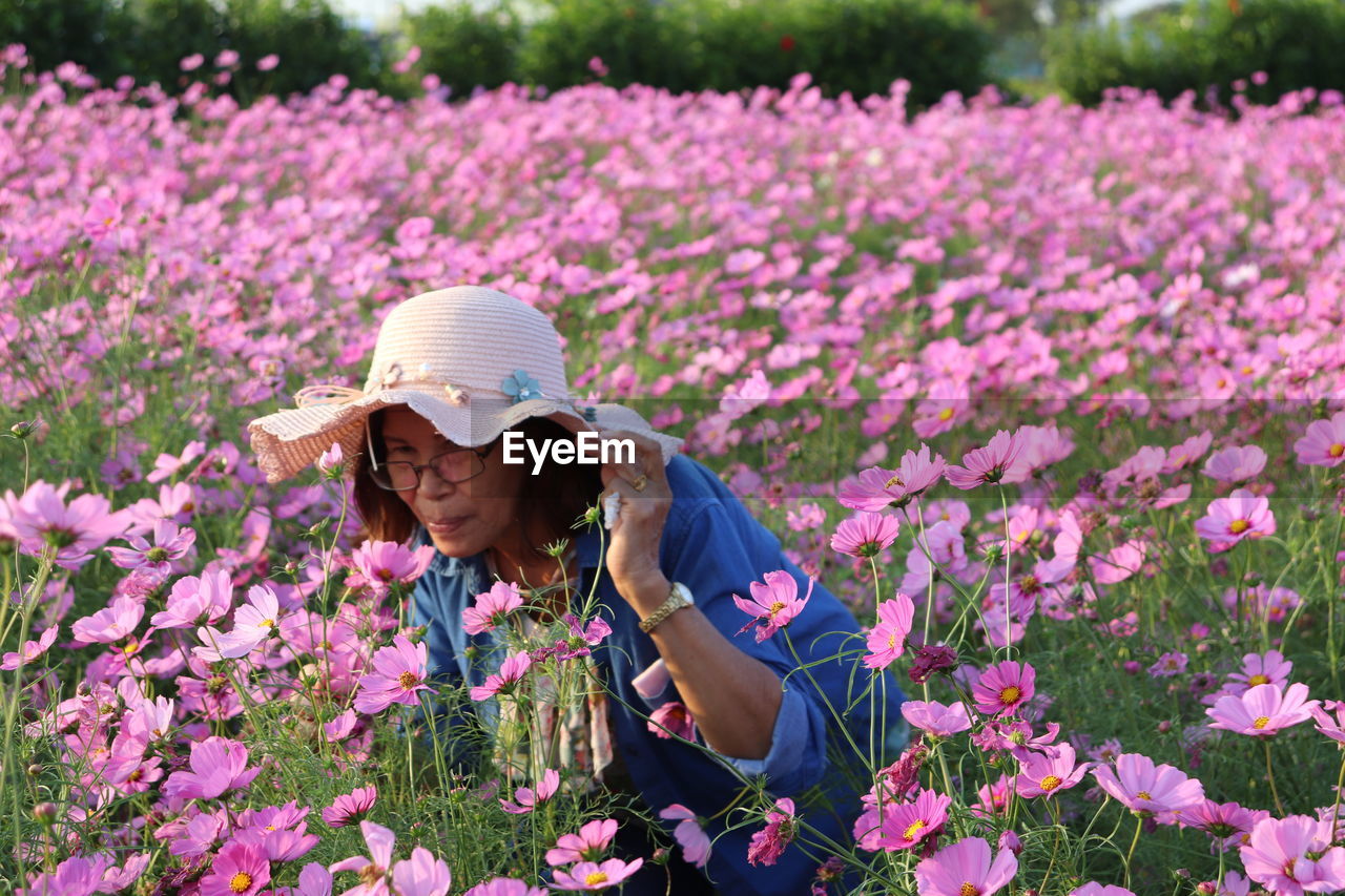 Portrait of woman by pink flowering plants