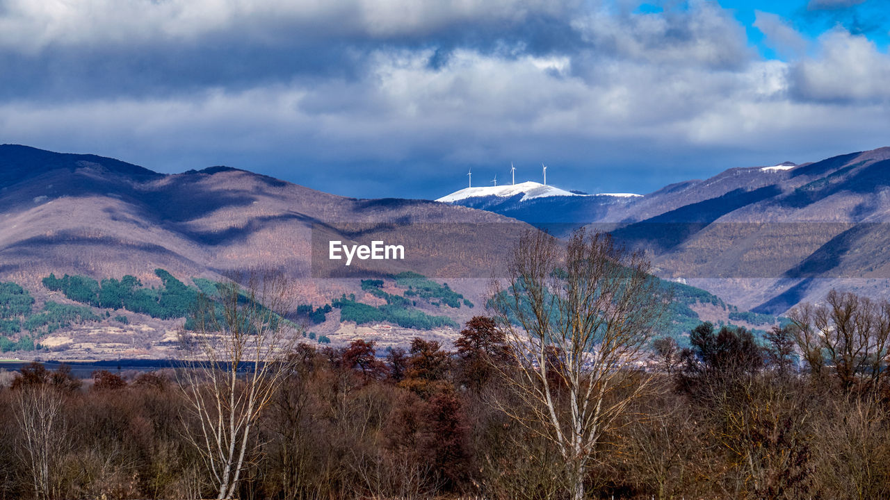 Scenic view of mountains and windmills against sky