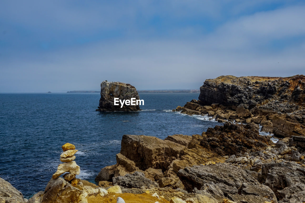 Scenic view of rocks in sea against sky